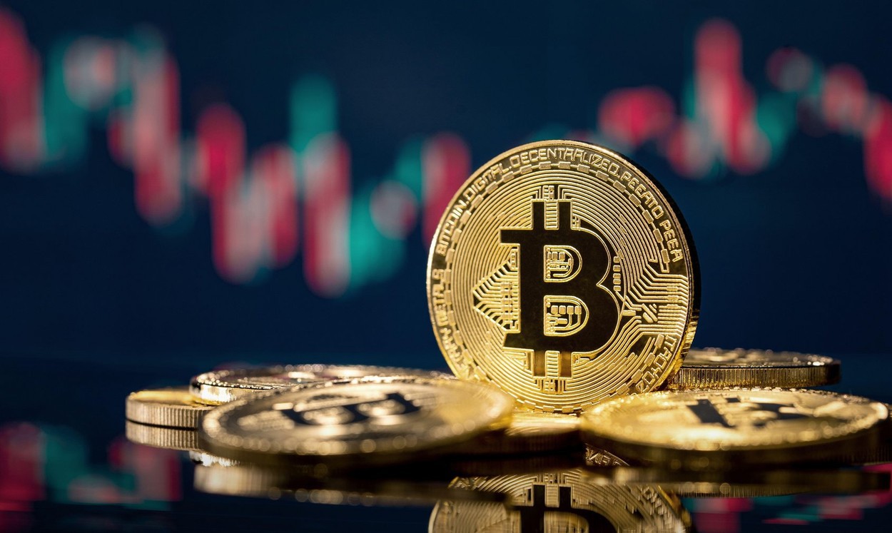 Golden bitcoin coin over defocused stock chart with copy space