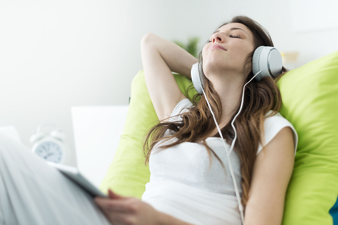 Beautiful,Young,Woman,With,Headphones,Relaxing,On,The,Bed,,She